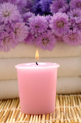 Fototapeta na wymiar Body relax composition with pink flower and candle on mat