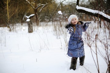 Fototapeta na wymiar Little girl playing snowballs