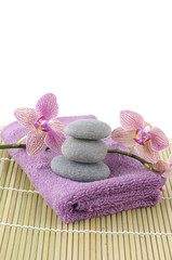 Obraz na płótnie Canvas stone tower on pink towel with orchid on bamboo stick straw mat