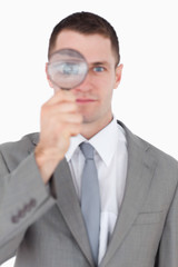 Fototapeta na wymiar Portrait of a businessman looking through a magnifying glass