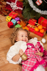 Fototapeta na wymiar Little girl lying near Christmas tree and smile