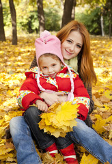 Mother and daughter in autumn yellow park