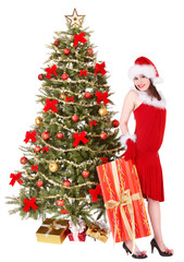 Girl in santa hat holding  gift box by christmas tree..