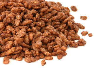 Chocolate popped rice cereals scattered on white background