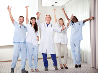 Group of happy doctors smiling and waving