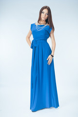Young woman in blue dress posing in studio