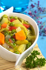 Vegetable soup made of carrot, leek, pea, potato, onion, tomato