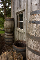 Barrels stacked against old house