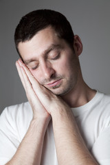 Naklejka premium A man holding his hands against his face and sleeping