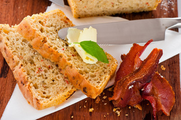 Homemade mediterranean bread with butter bacon and a leaf of bas