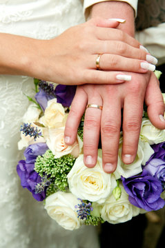 Just married couple hands. Rings and flowers