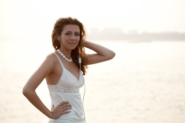 Fototapeta na wymiar woman with earphones in ears over sunset