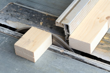 Carpenter cutting wood on electric saw