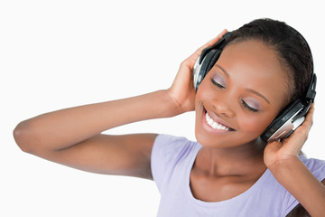 Naklejka premium Close up of woman listening to music against a white background