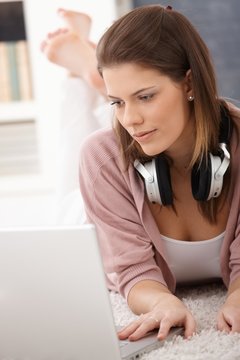 Young woman using laptop on floor