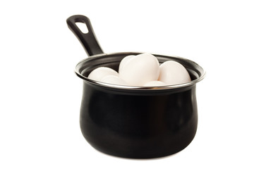 Eggs in a black cooking pot isolated on white