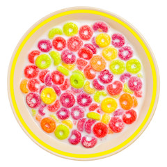 Colorful children's cereal in a bowl with milk isolated on white