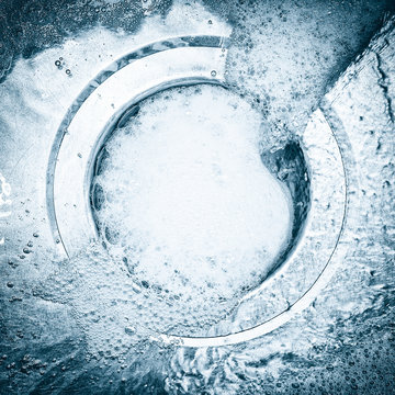 Soap bubbles and water going down the sink