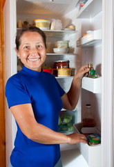 mature woman looking in fridge