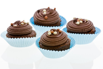 Chocolate cupcake with decorations on white.