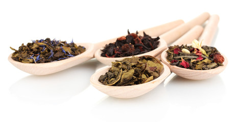 Different dry green and black tea in wooden spoons