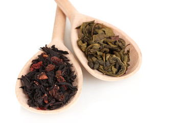 Dry green and black tea in wooden spoons isolated on white