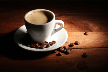 cup with coffee and coffee beans on  wooden table