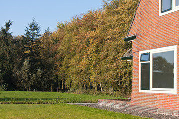 Dutch house surrounded with meadows and a forest