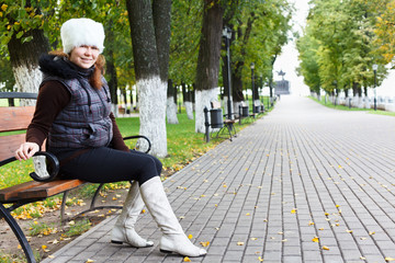 Young beautiful woman sitting alone on a park bench