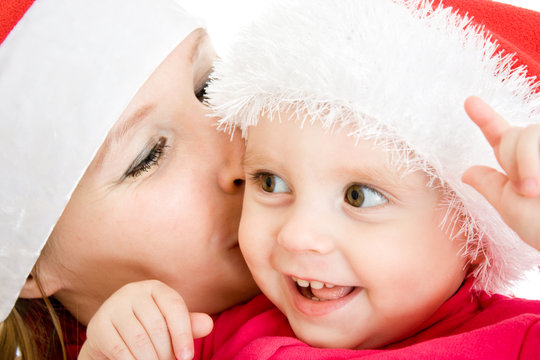 Happy Christmas mother kissing daughter on a white background.