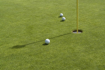 hole and golf balls in green back