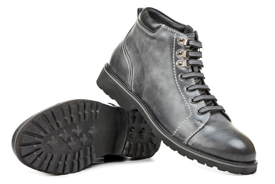 Pair of grey ankle-high men boots over white