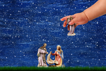 Presepio con bambino che mette statuina