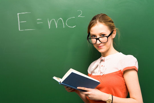 Female student by chalkboard with e=mc2