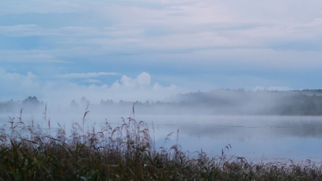 Autumnal evening on the lake, birth of fog