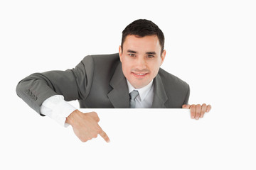 Businessman pointing at sign under him