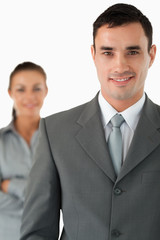 Close up of smiling businessman with colleague behind him