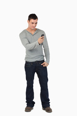 Young male standing and reading text message