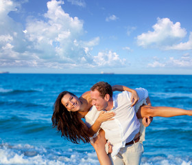 Fototapeta na wymiar couple in love piggyback playing in beach
