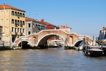 Fototapeta na wymiar Stone bridge with three arches on a canal in Venice, Italy