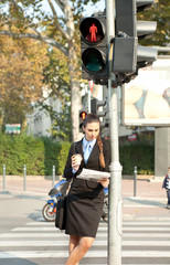 businesswoman leaning on the traffic light