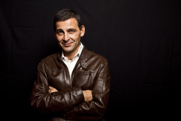Fototapeta premium portrait of a cool mature man with leather jacket over black bac