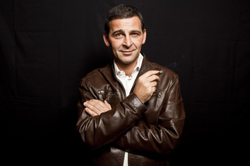 Fototapeta premium portrait of a cool mature man with leather jacket over black bac