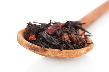 Black fruit dry tea leaves in woooden spoon isolated on white