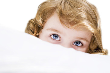 Bambina che si nasconde dietro al cuscino