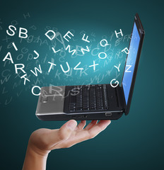 mans hand holds the laptop