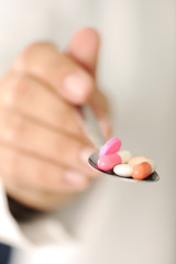 Doctor with pills in spoon