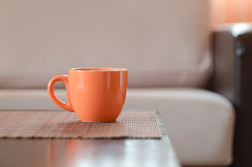 Orange cup on table in front of sofa