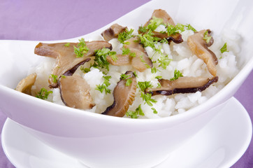 Risotto Reis in einer Schale mit Pilzen und Petersilie