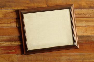 Vintage wooden picture frame on the old wooden wall